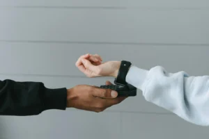 A shopper uses a smartwatch for contactless payment at a terminal, illustrating modern digital payment habits among Gen Z.