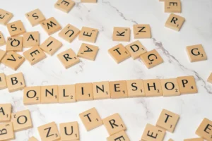 Scrabble tiles arranged on a marble surface spelling out "ONLINE SHOP," symbolizing the start of a new e-commerce venture.
