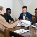 "Group of lawyers discussing documents around a table, representing legal preparation for fighting insurance companies."