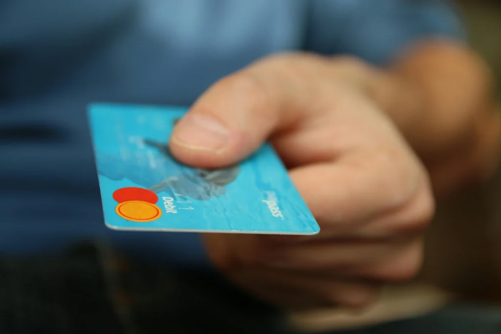 "Close-up of a hand holding a blue credit card, symbolizing online shopping and digital payment in e-commerce."
