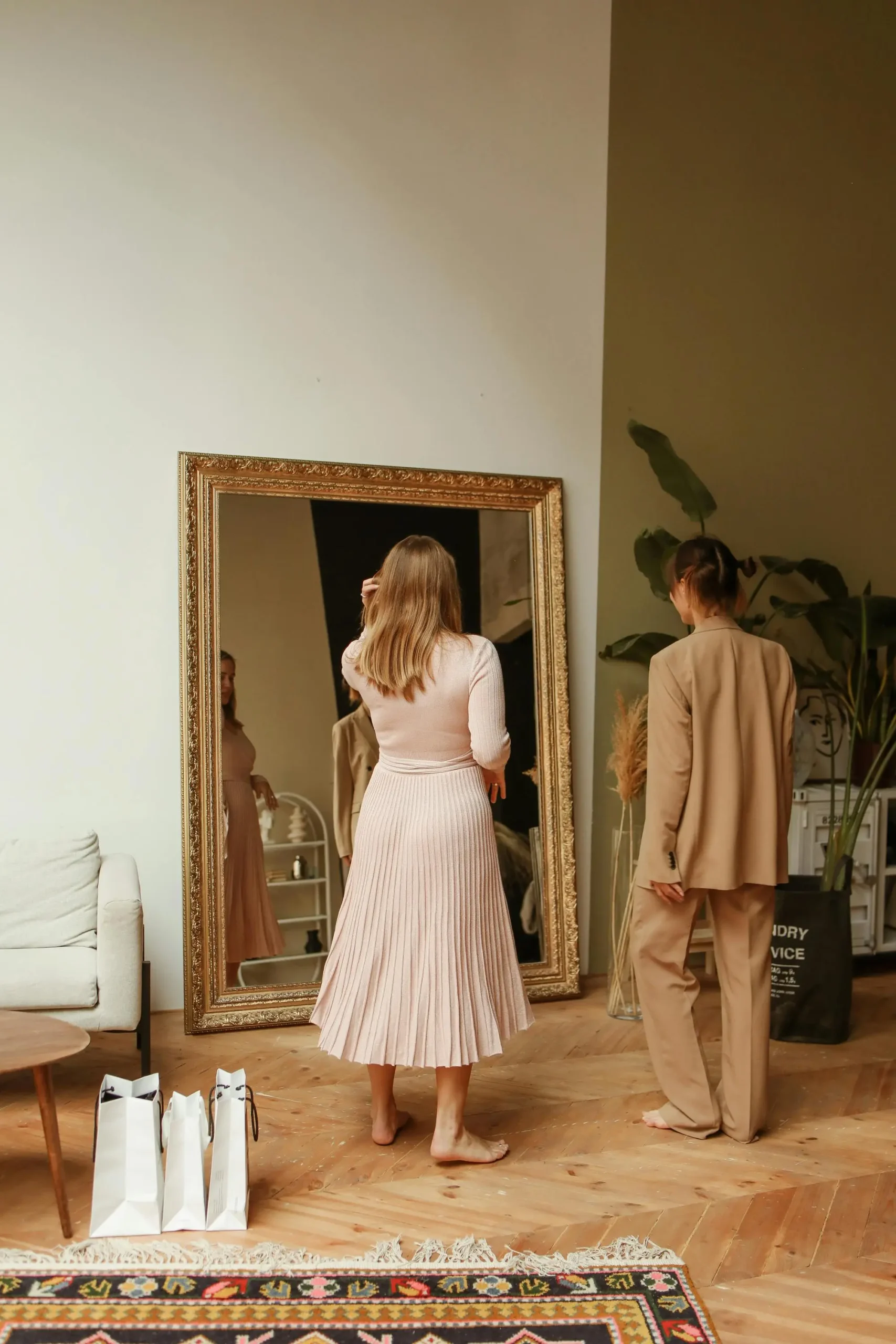 Two women in a stylish boutique trying on clothes in front of a mirror — illustrating the ‘Try Before You Buy’ experience in modern fashion retail.