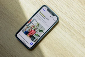 Smartphone on a wooden surface displaying a fitness apparel product page, emphasizing mobile-optimized e-commerce interfaces.