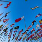 “Multiple national flags representing different countries where international students can study in English-speaking universities without IELTS requirement.”