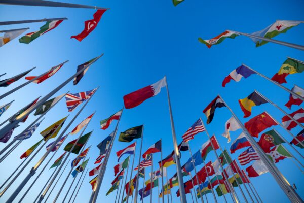 “Multiple national flags representing different countries where international students can study in English-speaking universities without IELTS requirement.”